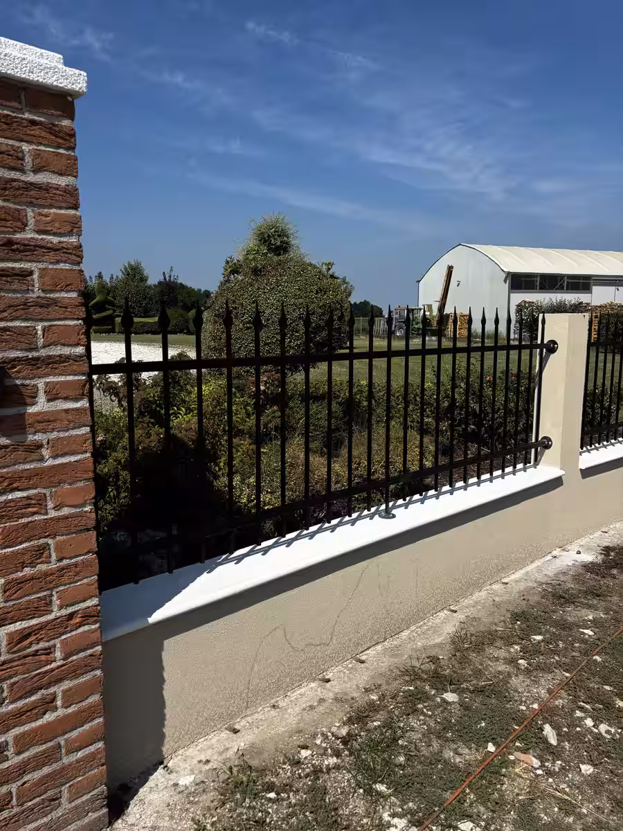 Cancello scuro lavorato in metallo per ingresso residenziale